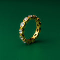 Amber Oval Bezel Gold ring with embedded diamonds on a green background