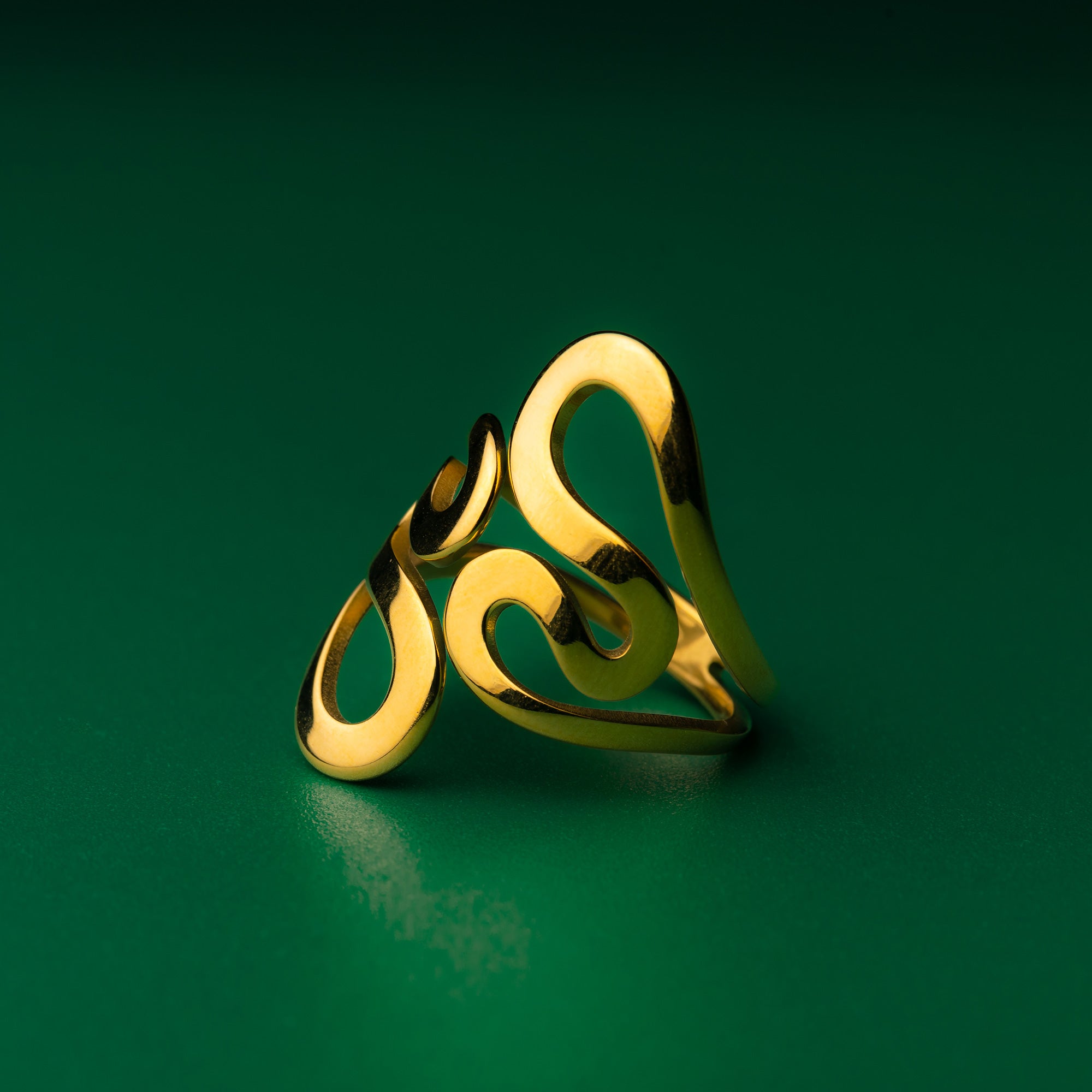 Coastal wave gold ring with a Celtic design on a green background
